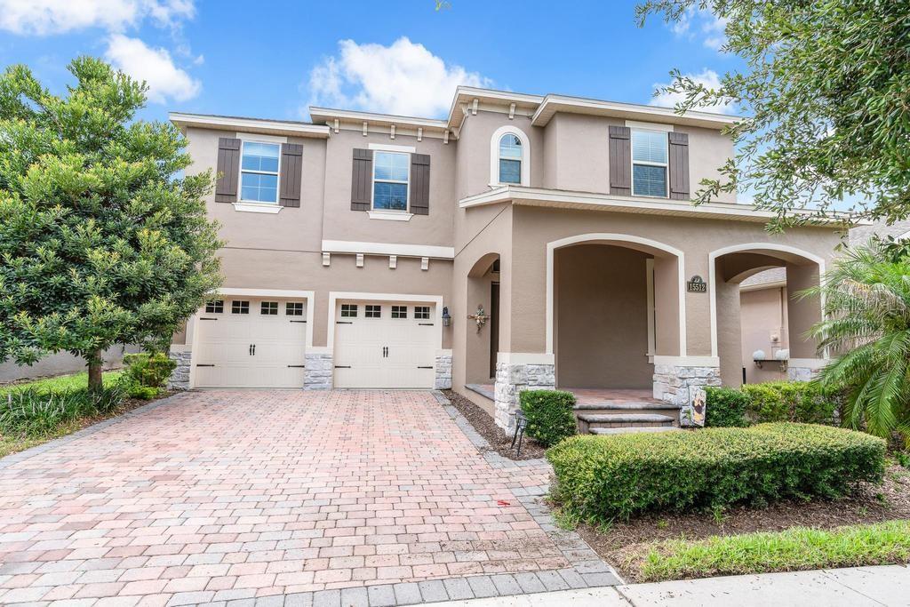 A two-story house with a two-car garage, stone accents, and a paved driveway — 15512 FOUNTAIN COVE COURT, WINTER GARDEN, FL