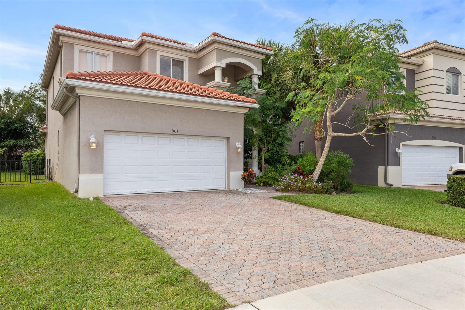 A two-story house with a tiled roof, a paved driveway, and a white garage door — 1017 Grove Park Circle, Boynton Beach FL 33436, BOYNTON BEACH, FL