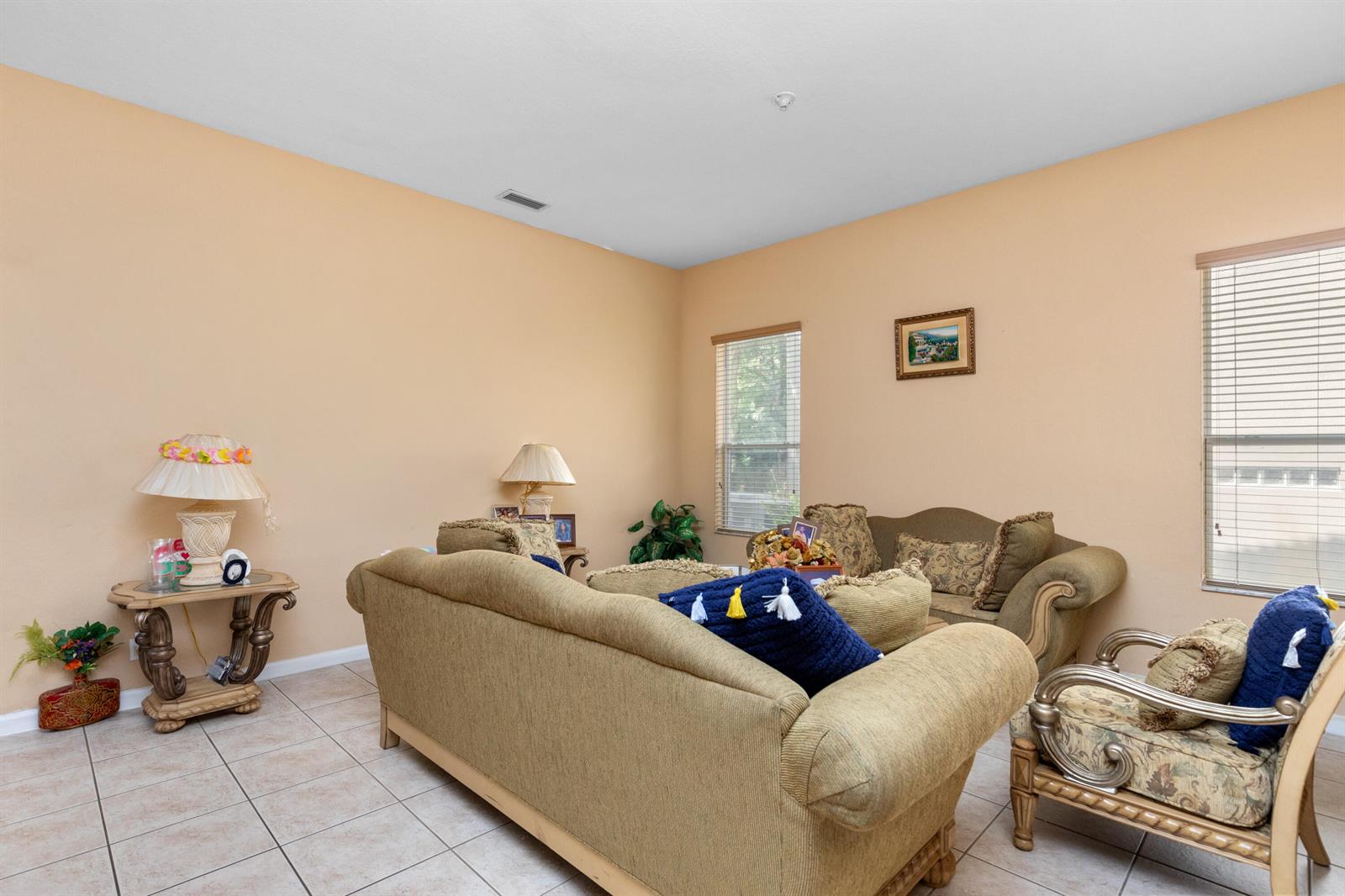 A living room features beige walls, tile flooring, two sofas, and an armchair — 1017 Grove Park Circle, Boynton Beach FL 33436, BOYNTON BEACH, FL