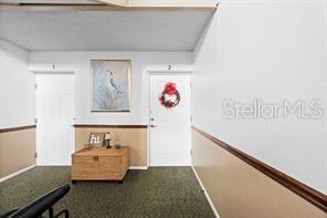 A hallway features two numbered doors, a wooden chest, and a framed picture on the wall — 1001 PLANTATION DRIVE UNIT B2, KISSIMMEE, FL