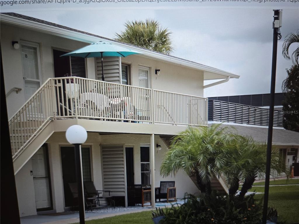 A two-story apartment building with a balcony, outdoor seating, and a palm tree — 1935 CONWAY DRIVE UNIT 05, ORLANDO, FL