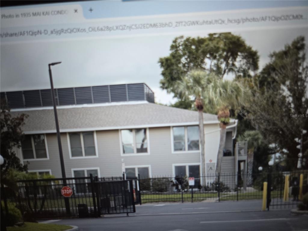 A two-story apartment building with light siding, a shingled roof, and a gated entrance — 1935 CONWAY DRIVE UNIT 05, ORLANDO, FL
