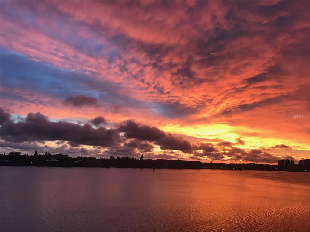 A vibrant sunset with orange and purple clouds over a calm body of water — 7932 SAILBOAT KEY BOULEVARD S UNIT 101, SOUTH PASADENA, FL