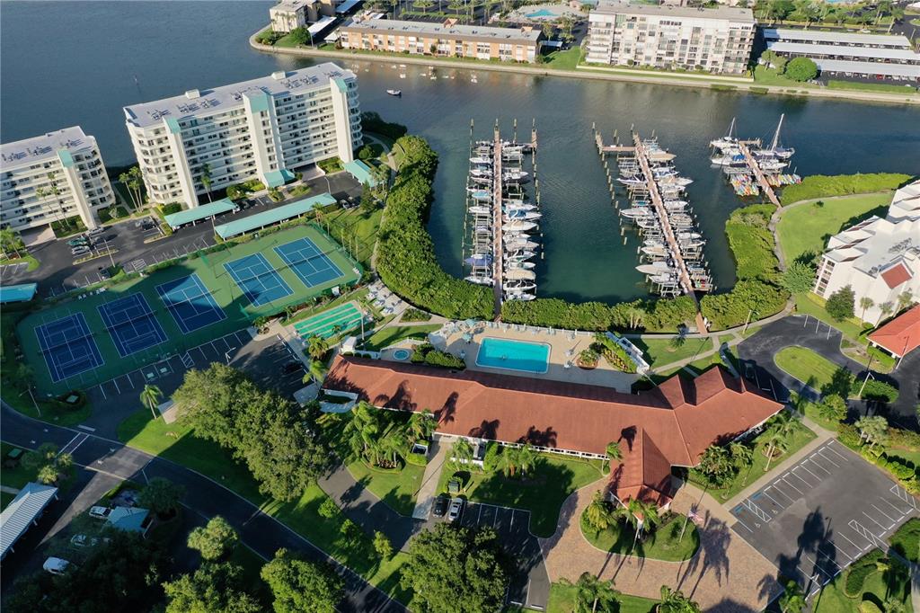 Aerial view of a residential complex featuring a marina, tennis courts, and a swimming pool — 7932 SAILBOAT KEY BOULEVARD S UNIT 101, SOUTH PASADENA, FL