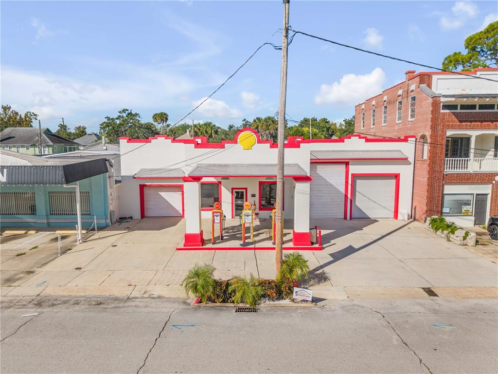 An exterior view of a historic-style building with a Shell logo and vintage gas pumps — 208 MAGNOLIA ST, NEW SMYRNA BEACH, FL