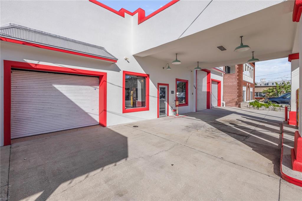 The exterior of a white building with red trim features a covered drive-through service area — 208 MAGNOLIA ST, NEW SMYRNA BEACH, FL