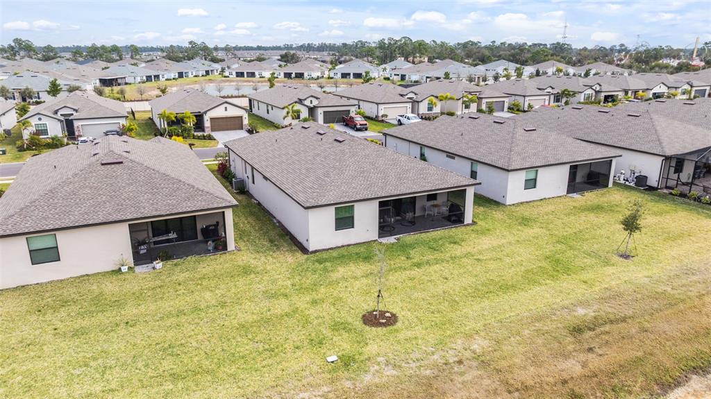 A single-story house with a tan exterior, a two-car garage, and palm trees in front — 1505 SADDLEWOOD CIRCLE, PORT CHARLOTTE, FL