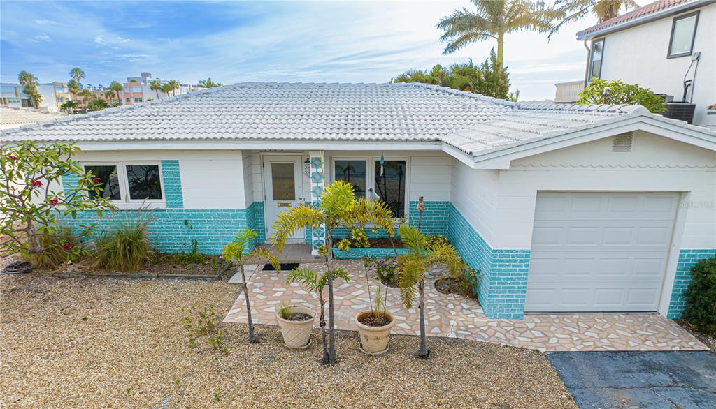 A single-story house with a white roof, turquoise brick accents, and a front-facing garage — 1425 COREY WAY S, SOUTH PASADENA, FL