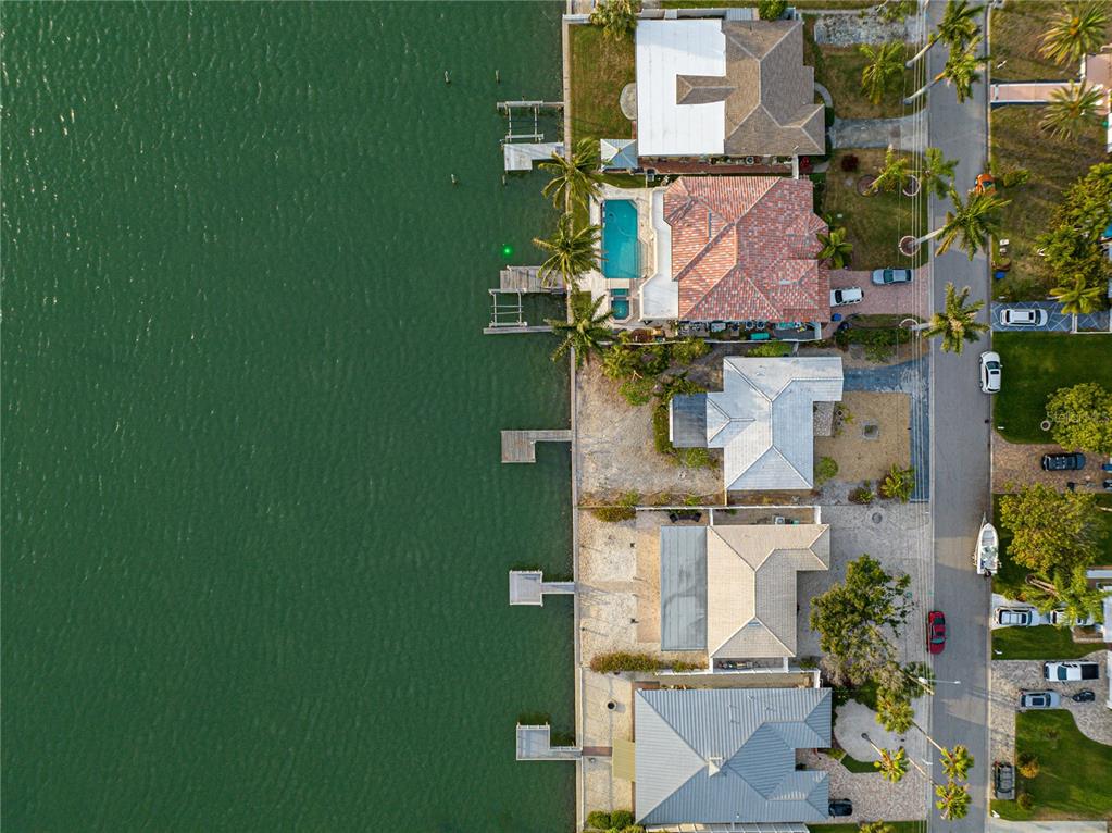 An aerial view shows several waterfront homes with private docks along a canal — 1425 COREY WAY S, SOUTH PASADENA, FL