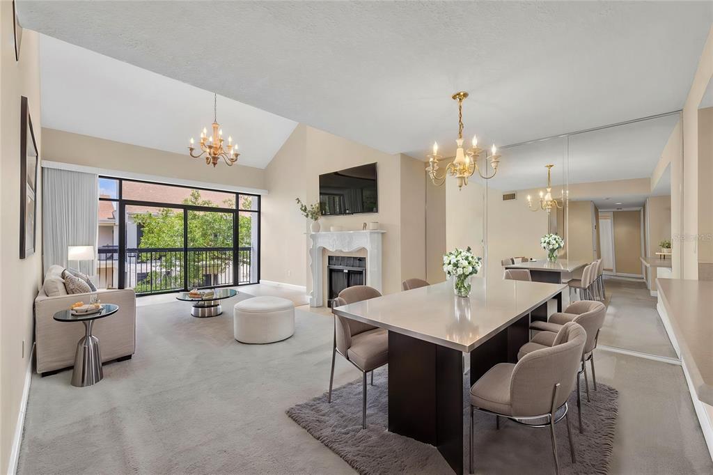 An open-concept living and dining room with a fireplace, vaulted ceilings, and a balcony view — 300 CAROLINA AVENUE UNIT 402C, WINTER PARK, FL