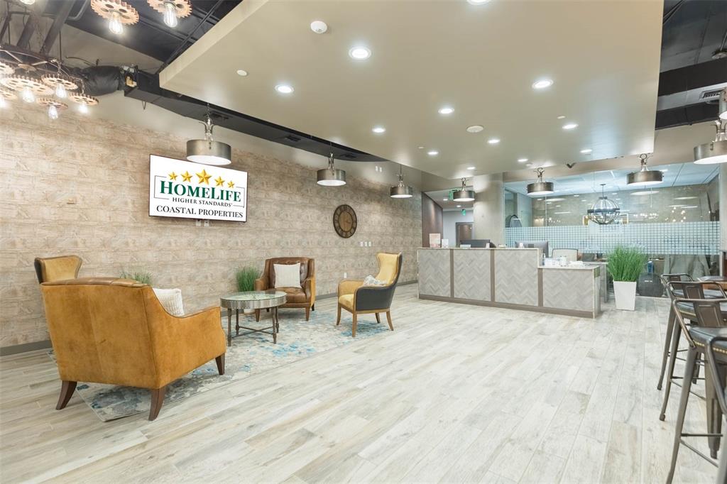 A modern office lobby features a reception desk, seating area, and wood-look tile flooring — 400 N ASHLEY DRIVE UNIT 2653, TAMPA, FL