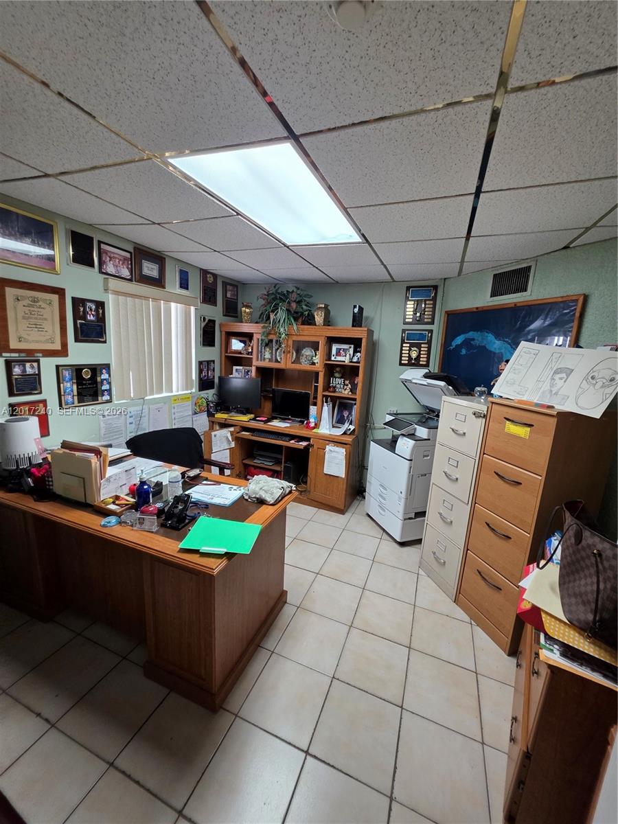 A cluttered office features a wooden desk, hutch, filing cabinets, and a drop ceiling — 2660 SW 17th St, Miami FL 33145, MIAMI, FL