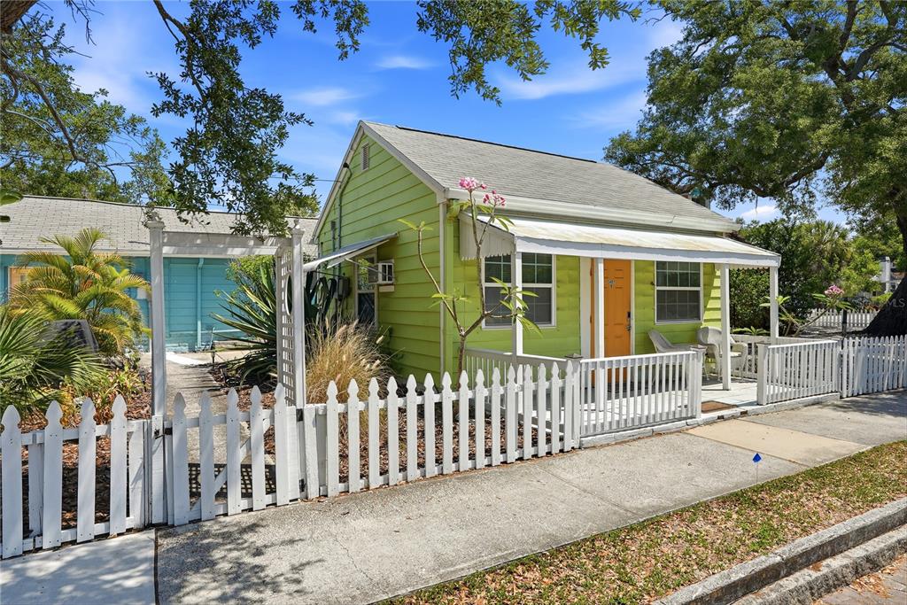 A lime green cottage with a white picket fence and a covered front porch — 5407 29TH AVENUE S, GULFPORT, FL