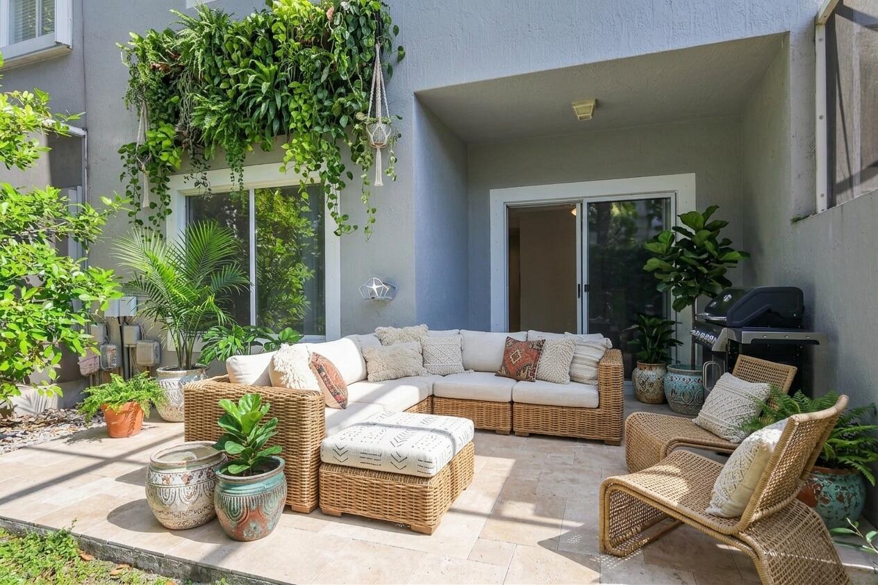 A patio features wicker furniture, potted plants, a grill, and a hanging vertical garden — 8297 Via Leonessa, Boca Raton FL 33433, BOCA RATON, FL