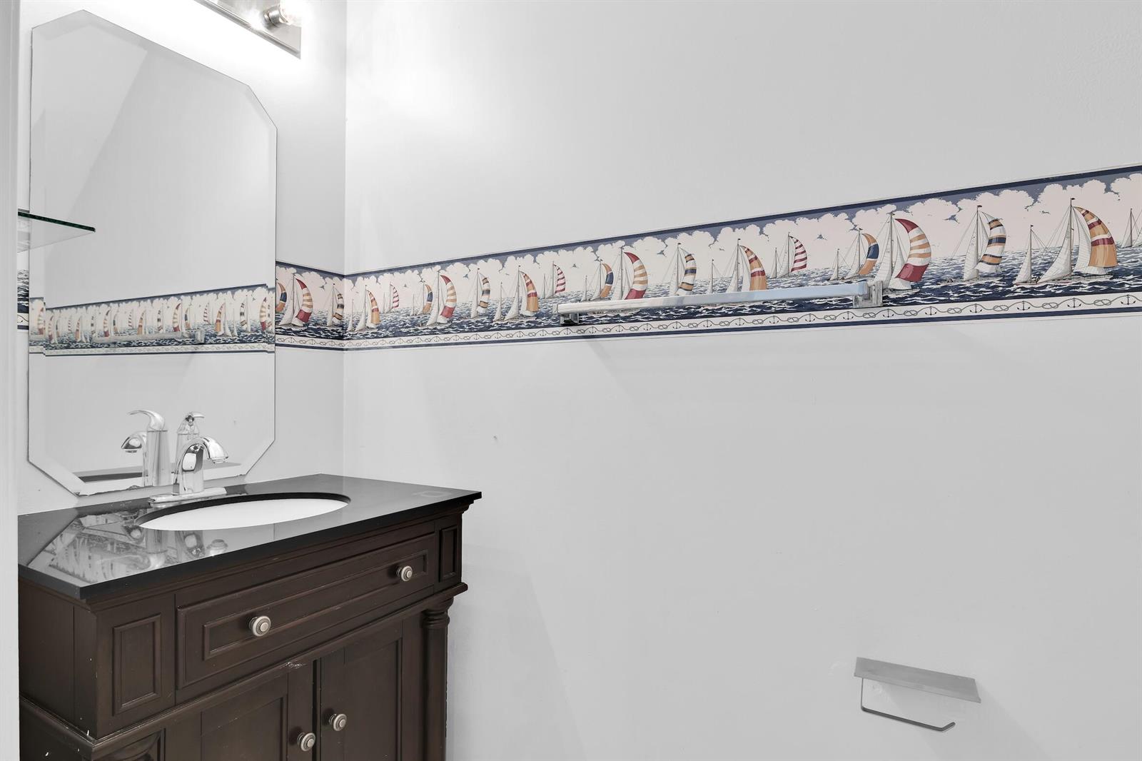 A bathroom features a dark wood vanity, a black countertop, and sailboat-themed wallpaper border — 8297 Via Leonessa, Boca Raton FL 33433, BOCA RATON, FL