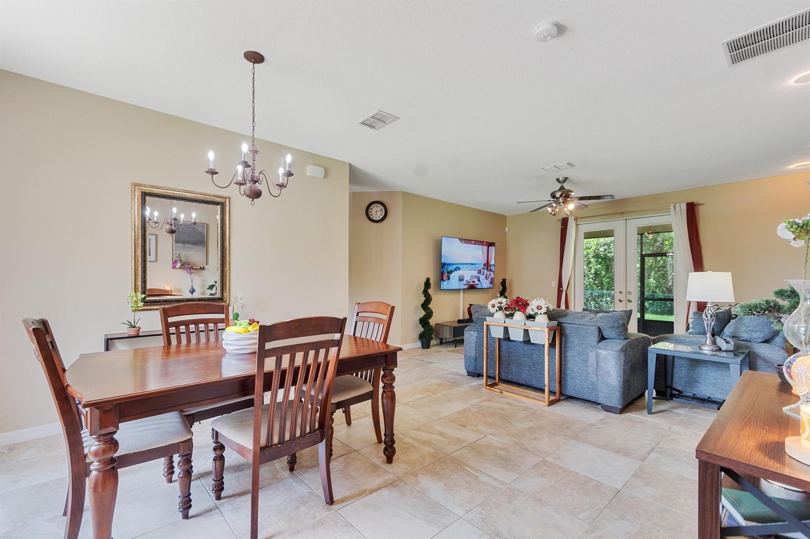 A dining area with a wooden table and chairs opens into a living room — SEBASTIAN, FL