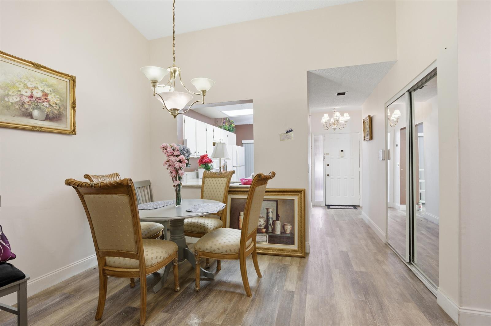 A dining area with a round table and chairs sits adjacent to a kitchen pass-through — 3582 Willa Way # B, Lake Worth FL 33467, LAKE WORTH, FL