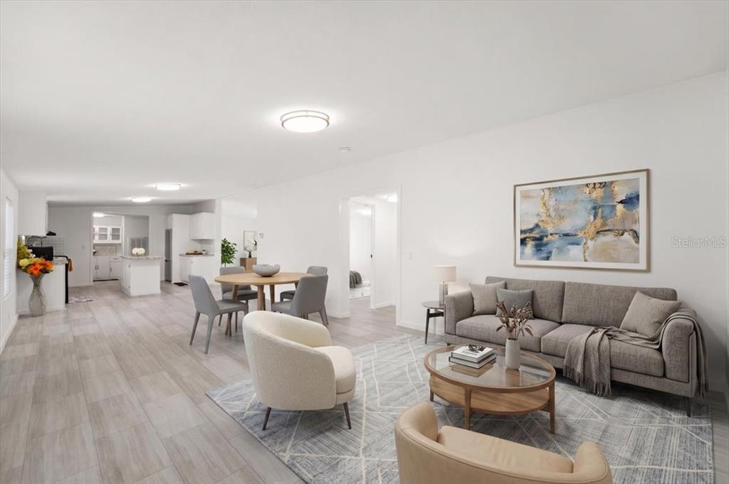An open-concept living and dining area features light wood-look flooring and neutral furnishings — 1137 YAUPON STREET, DAYTONA BEACH, FL