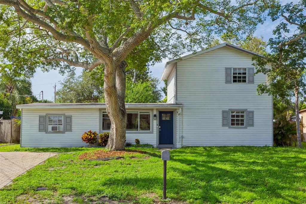 A two-story house with white siding, a blue front door, and a large tree out front — 4012 W FAIRVIEW HEIGHTS, TAMPA, FL