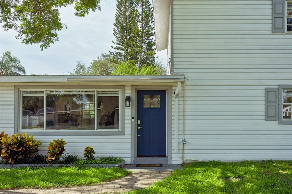 A blue front door is centered on the white horizontal siding of a two-story house — 4012 W FAIRVIEW HEIGHTS, TAMPA, FL