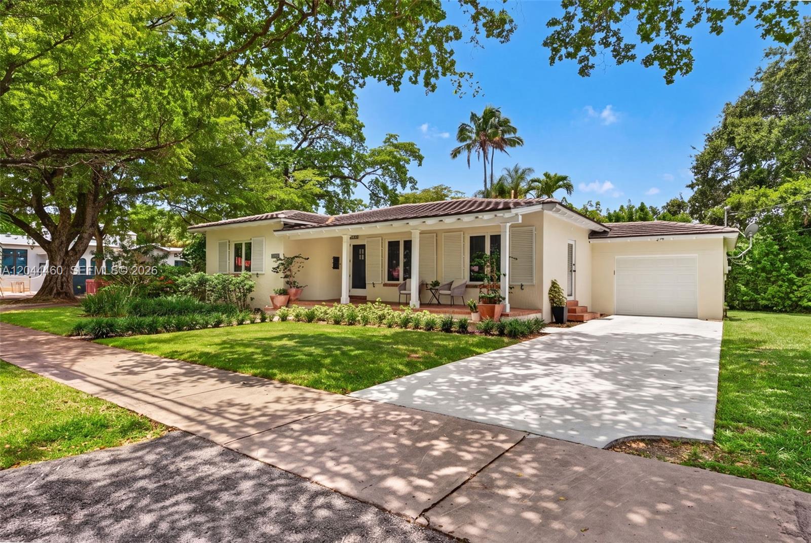 A single-story house with a white exterior, a covered front porch, and an attached garage — 1710 Segovia St, Coral Gables FL 33134, CORAL GABLES, FL