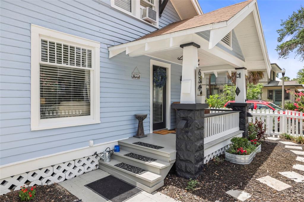 A light blue house features a front porch with stone pillars and white railings — 634 6TH STREET N, ST PETERSBURG, FL