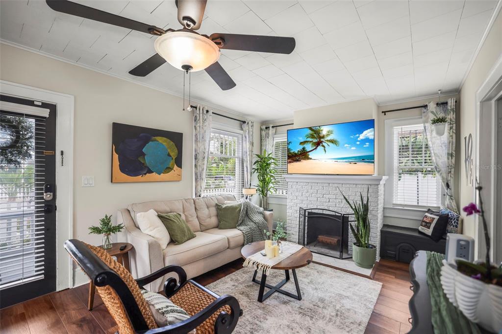 A living room features a white brick fireplace, a beige sofa, and a ceiling fan — 634 6TH STREET N, ST PETERSBURG, FL