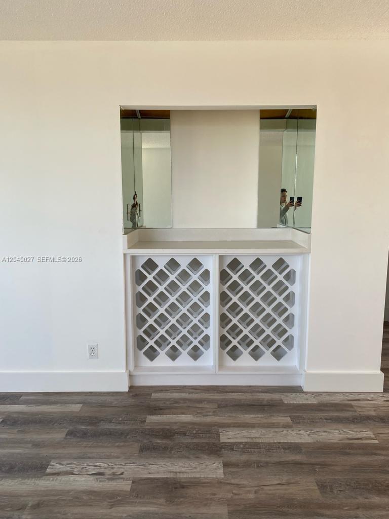 A built-in white bar features a countertop, mirrored backsplash, and diamond-patterned wine storage shelving — 406 NW 68th Ave # 526, Plantation FL 33317, PLANTATION, FL