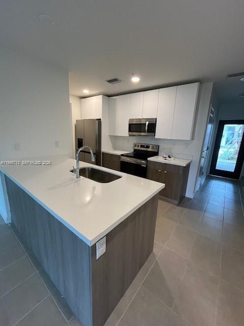 A modern kitchen features a white quartz island, wood-toned cabinetry, and stainless steel appliances — 2511 Pierce St # 1, Hollywood FL 33020, HOLLYWOOD, FL