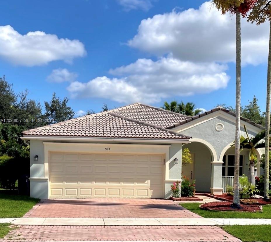 A single-story house with a beige stucco exterior, a two-car garage, and a tiled roof — 953 Tanglewood Cir # 953, Weston FL 33327, WESTON, FL