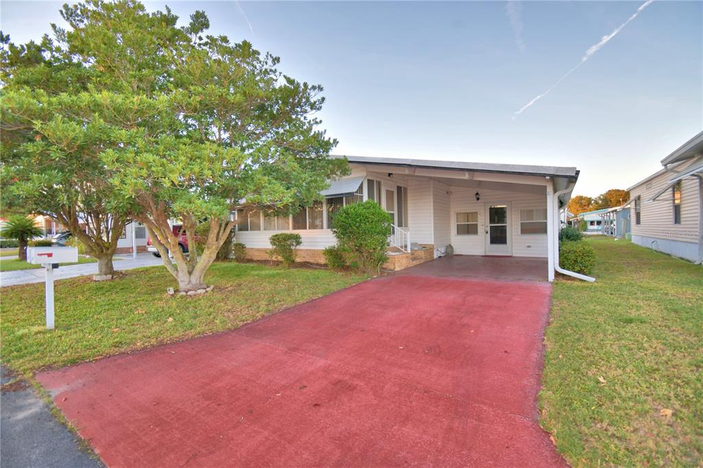 A single-story house with a red driveway, a carport, and a large tree in front — 4251 CEDARWOOD STREET, WINTER HAVEN, FL