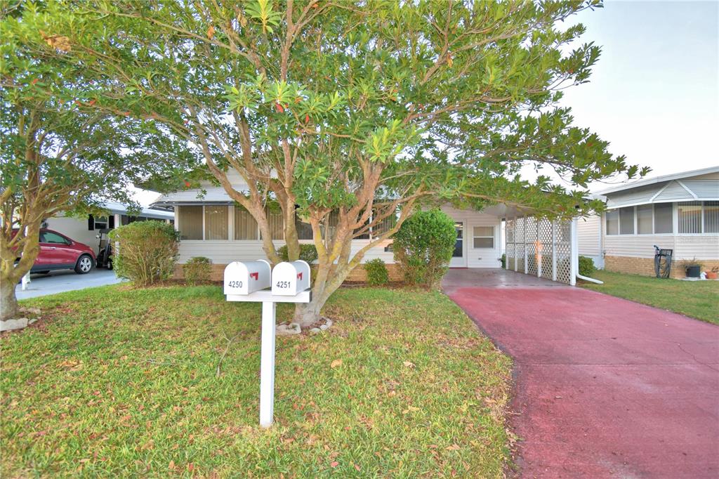 A single-story house with a red driveway, a carport, and two mailboxes on a post — 4251 CEDARWOOD STREET, WINTER HAVEN, FL