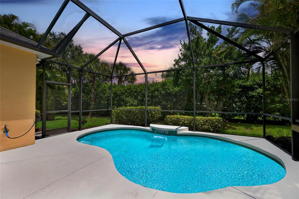 A screened-in patio features a kidney-shaped swimming pool with a small water feature — 12109 WHISPER LAKE DRIVE, BRADENTON, FL