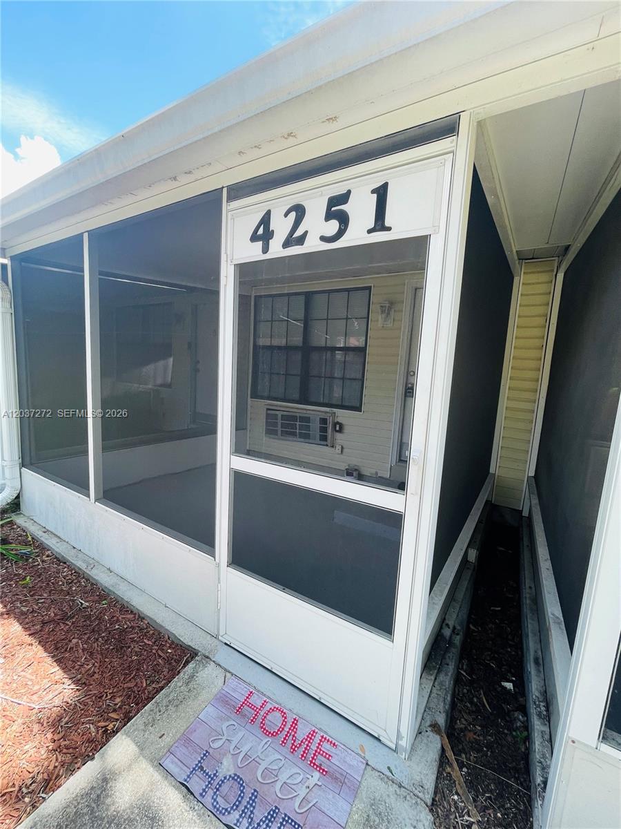 A screened-in porch features a white frame, a window, and a welcome mat — 4251 E Michigan Street # 4251, Orlando FL 32812, ORLANDO, FL