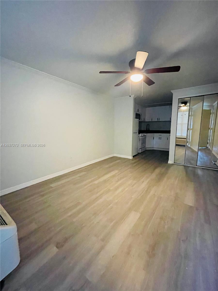 This room features light wood-look flooring, a ceiling fan, and an adjacent kitchen area — 4251 E Michigan Street # 4251, Orlando FL 32812, ORLANDO, FL