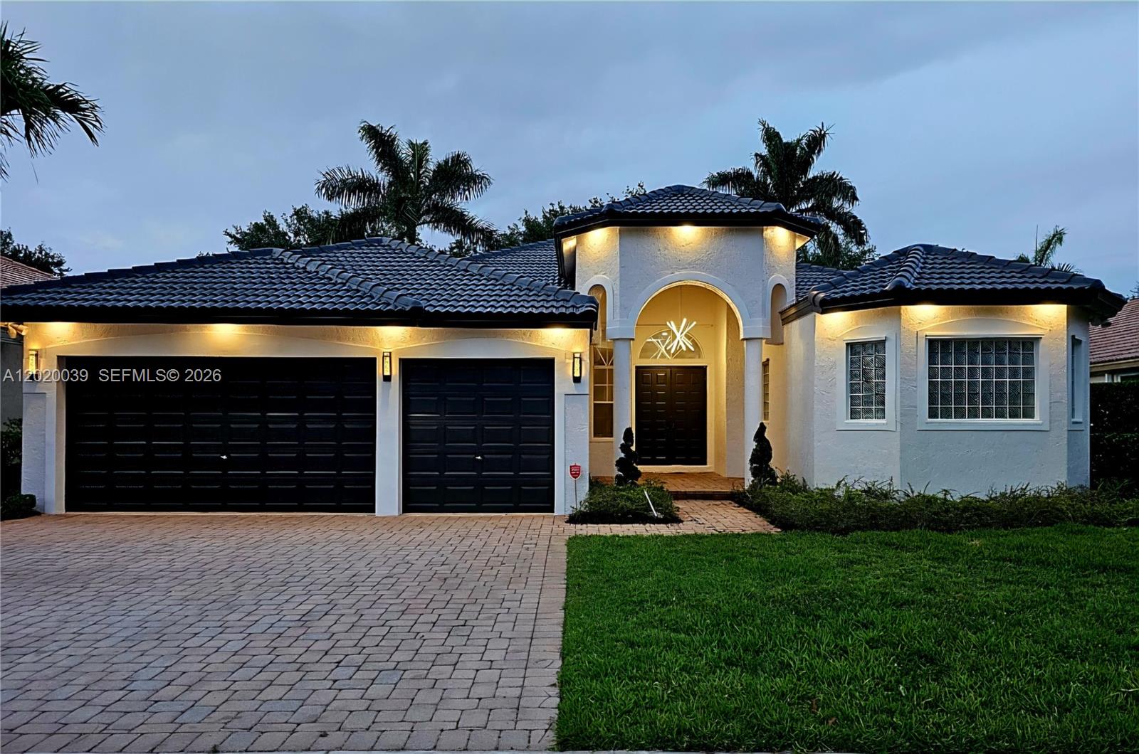 A single-story house with a dark tiled roof, white stucco walls, and a two-car garage — 18951 SW 30th St, Miramar FL 33029, MIRAMAR, FL