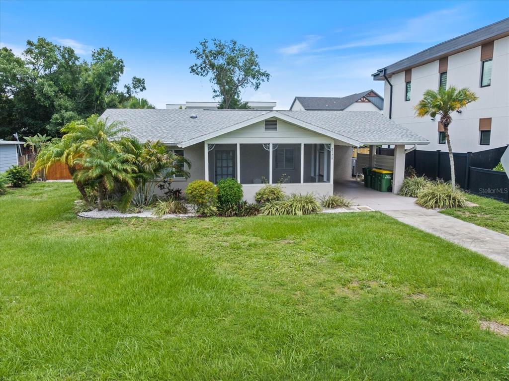 A single-story house with a screened front porch, a carport, and a grassy front yard — 2126 HYDE PARK STREET, SARASOTA, FL