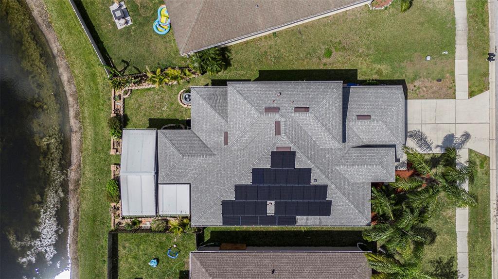 An aerial view shows a house with a shingled roof and a solar panel array — 3219 GIANNA WAY, LAND O LAKES, FL