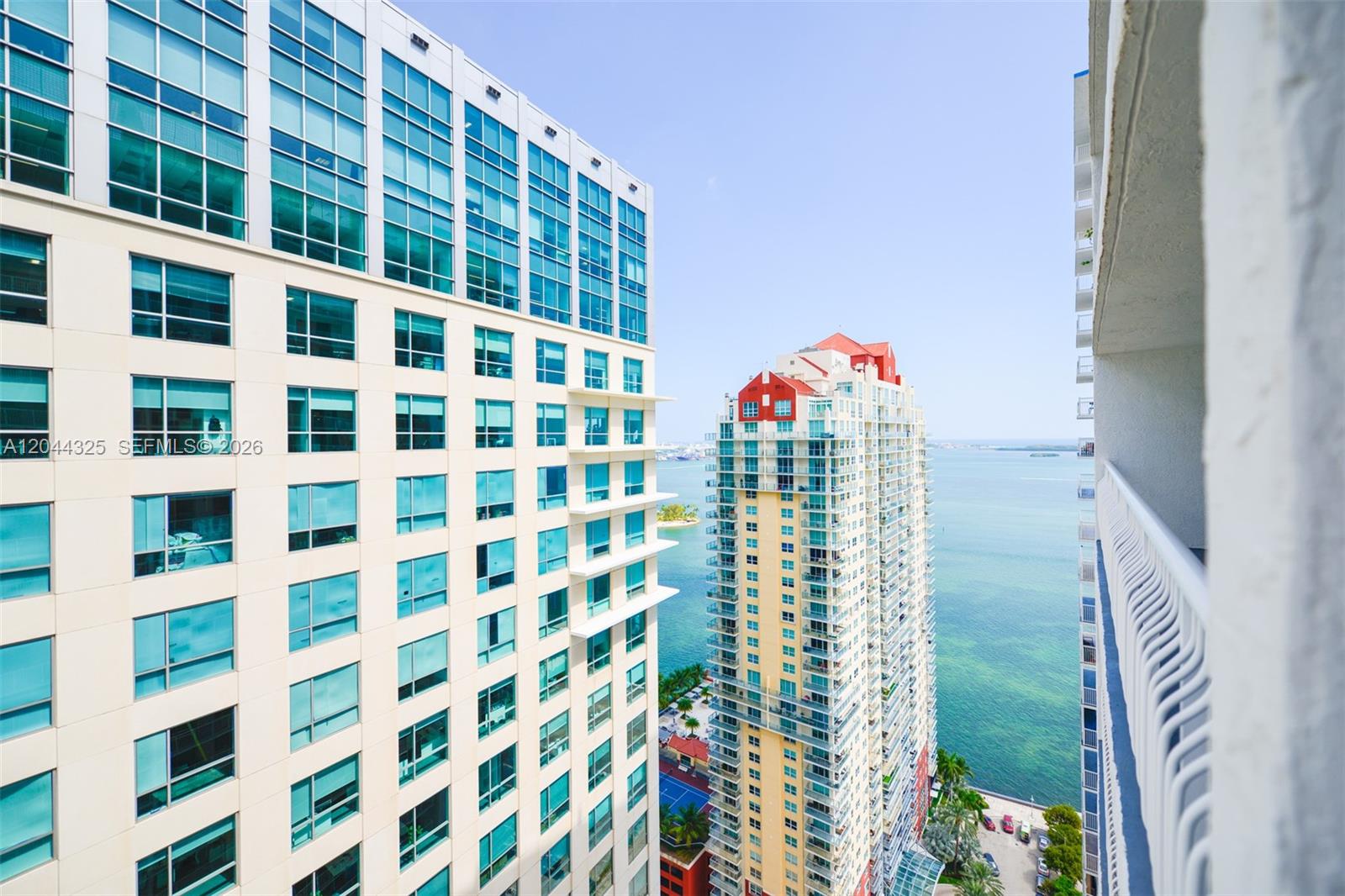 An exterior view shows two tall residential buildings overlooking a bay on a sunny day — 1200 Brickell Bay Dr # 3614, Miami FL 33131, MIAMI, FL
