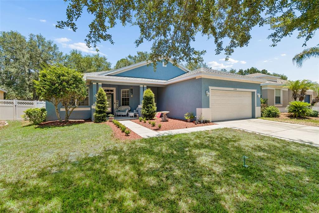 A blue single-story house with a two-car garage and a front porch — 11318 BRIDGE PINE DRIVE, RIVERVIEW, FL