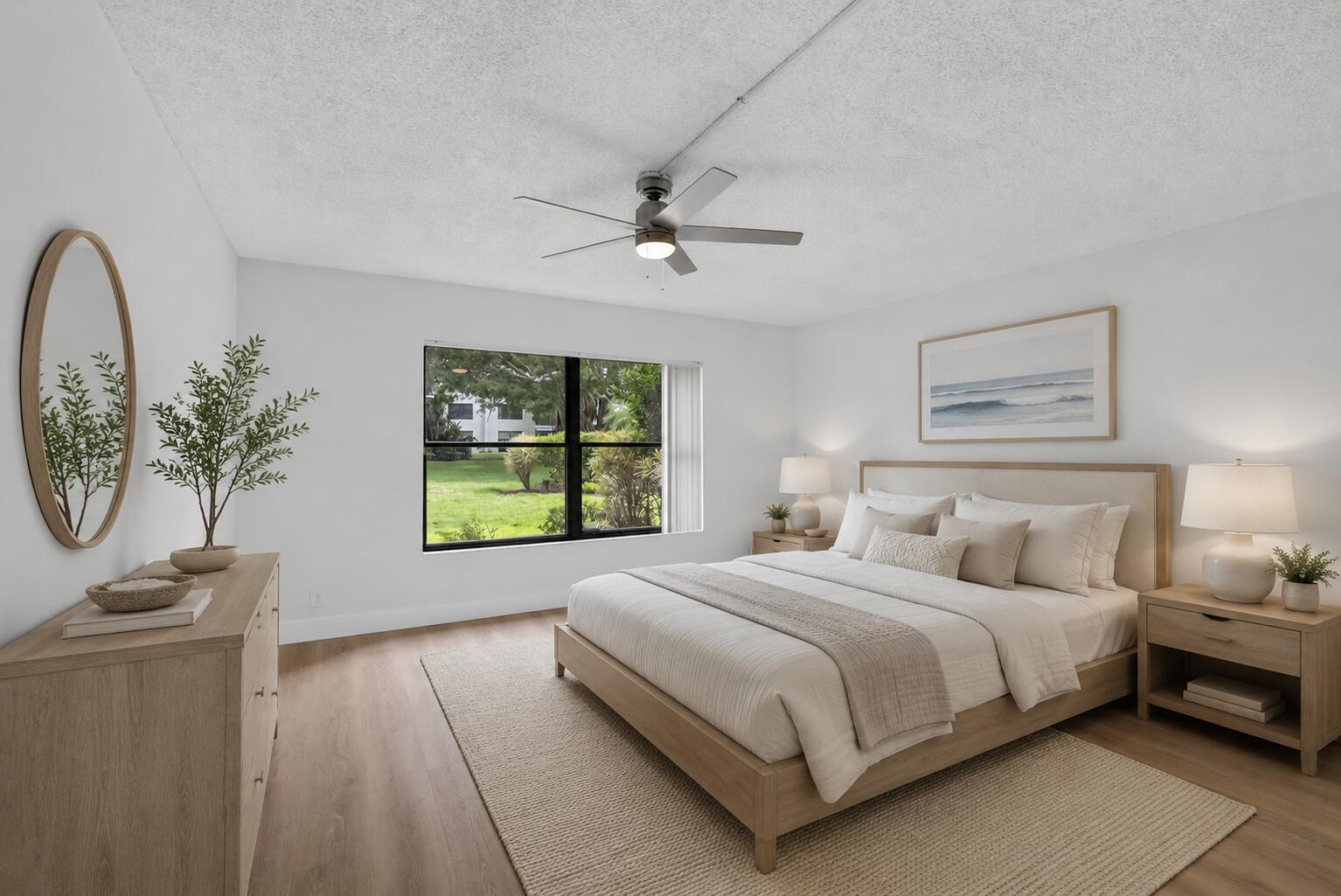 A bedroom features a bed, dresser, ceiling fan, and a window overlooking a grassy yard — 300 N Highway A1a # 104j, Jupiter FL 33477, JUPITER, FL