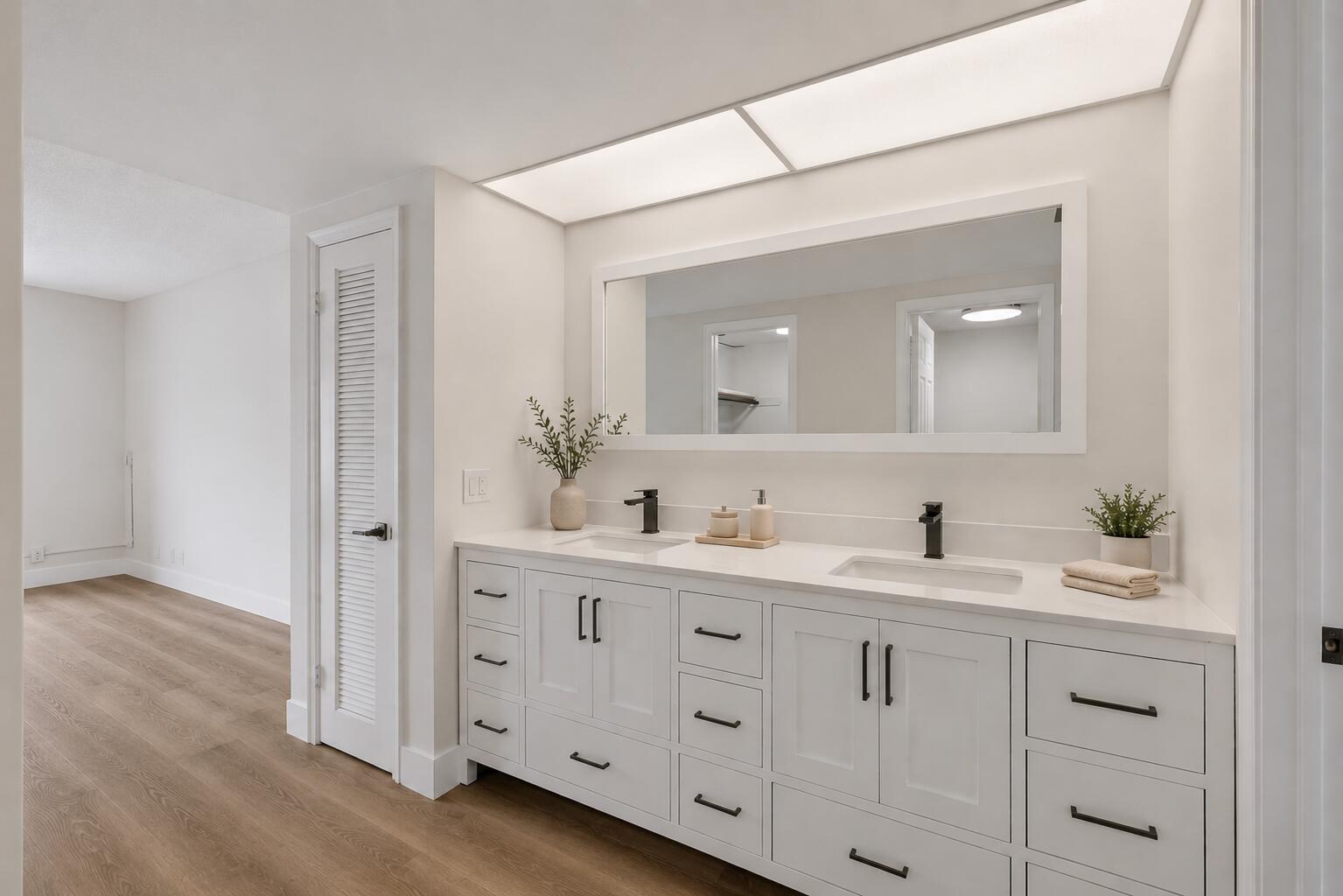 A modern bathroom features a white double vanity with black hardware and a large mirror — 300 N Highway A1a # 104j, Jupiter FL 33477, JUPITER, FL
