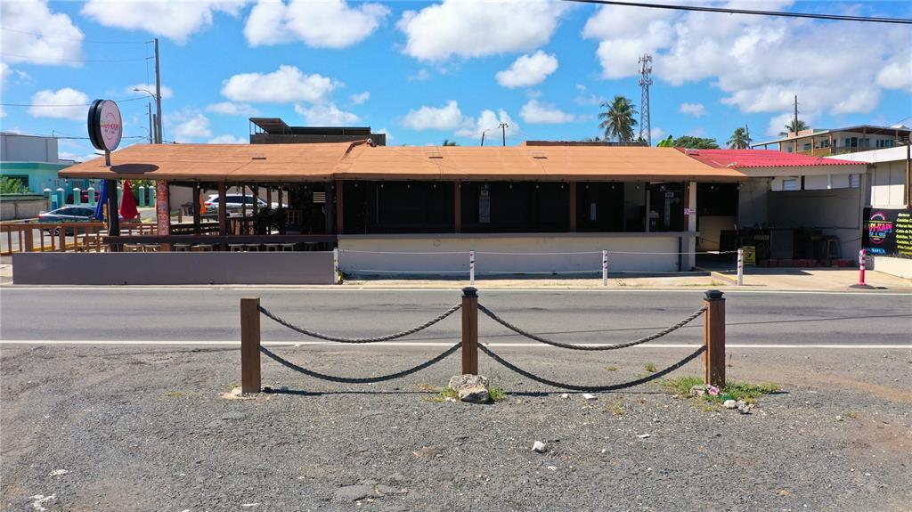 A single-story commercial building with a covered outdoor seating area and a gravel parking lot — Km 3.3 CARR 684, BARCELONETA, PR