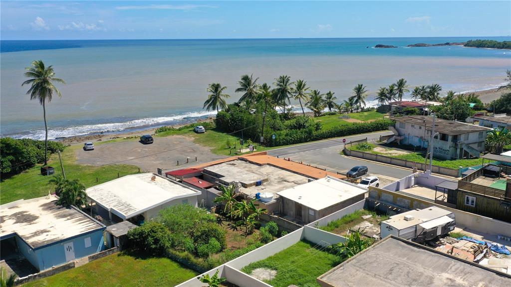 An aerial view shows a coastal property with several buildings, palm trees, and the ocean — Km 3.3 CARR 684, BARCELONETA, PR