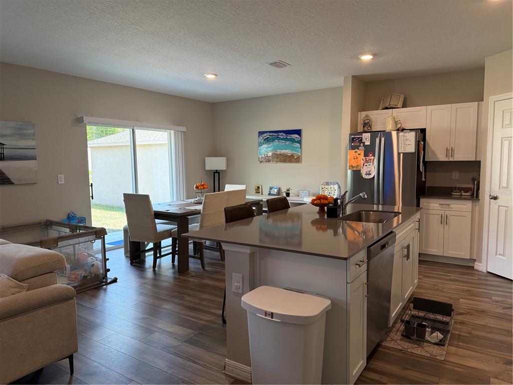 An open-concept kitchen with a center island, stainless steel appliances, and an adjacent dining area — 10960 3RD STREET, RIVERVIEW, FL