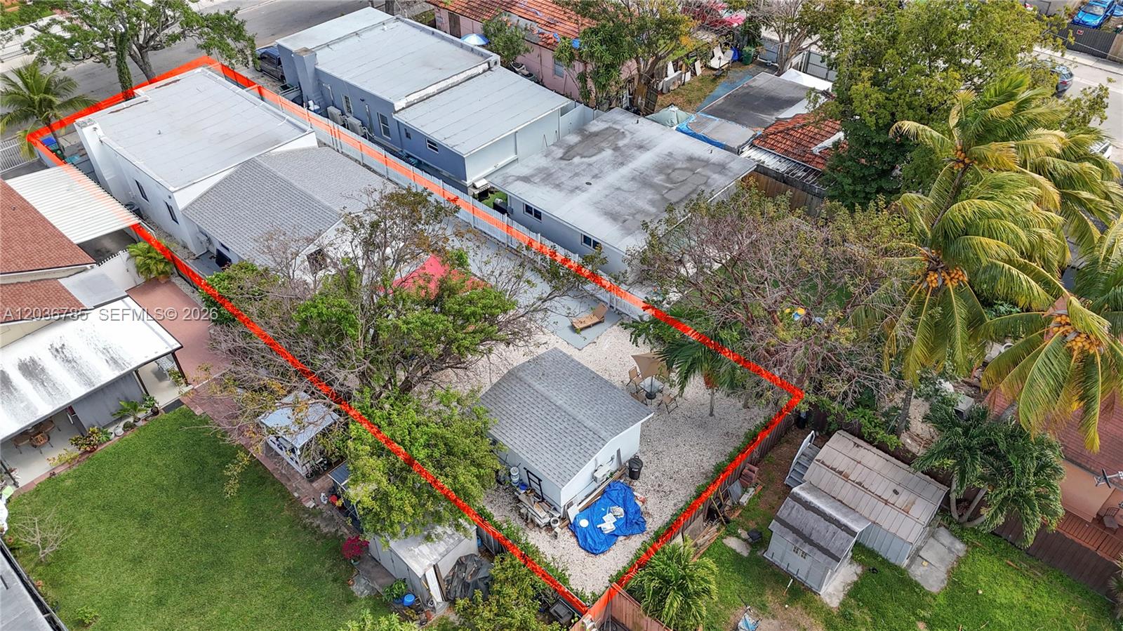 An aerial view shows a residential backyard with a detached structure, trees, and gravel landscaping — 3016 NW 22nd Ct # 3020, Miami FL 33142, MIAMI, FL