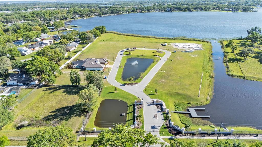 An aerial view shows a gated residential development with ponds, a fountain, and a lake — 5472 SHOREVIEW DRIVE, LAKELAND, FL