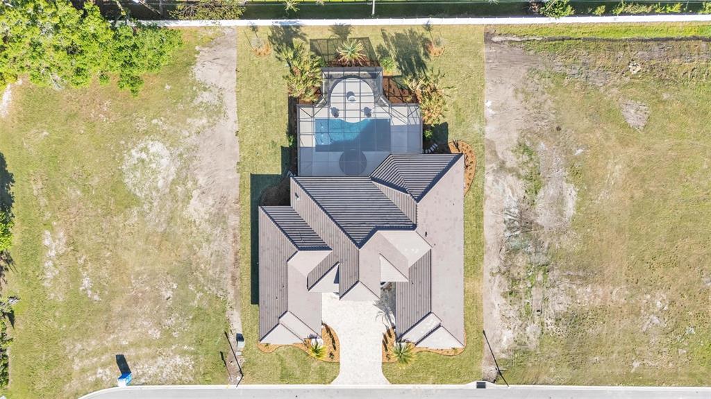 An aerial view shows a house with a pool enclosure situated on a large lot — 5472 SHOREVIEW DRIVE, LAKELAND, FL
