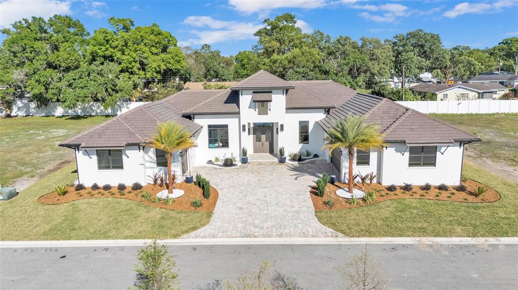 A modern white house with a brown tiled roof and a paved driveway — 5472 SHOREVIEW DRIVE, LAKELAND, FL