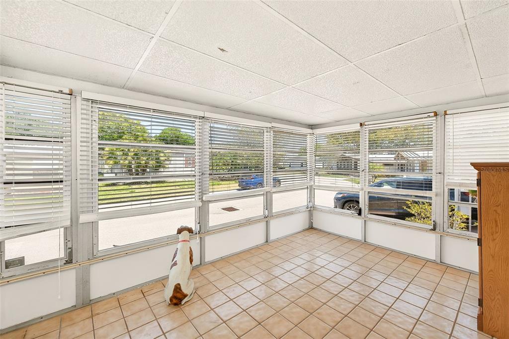 A sunroom with tile flooring, white walls, and multiple windows covered by horizontal blinds — 94 SUGAR BEAR DRIVE UNIT 55, SAFETY HARBOR, FL